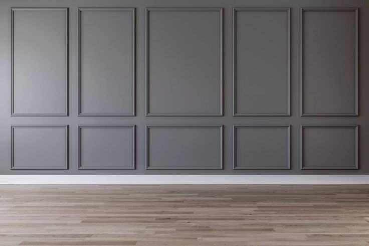 an empty room with gray walls and wooden floors is shown in this image, there are no people or objects on the wall