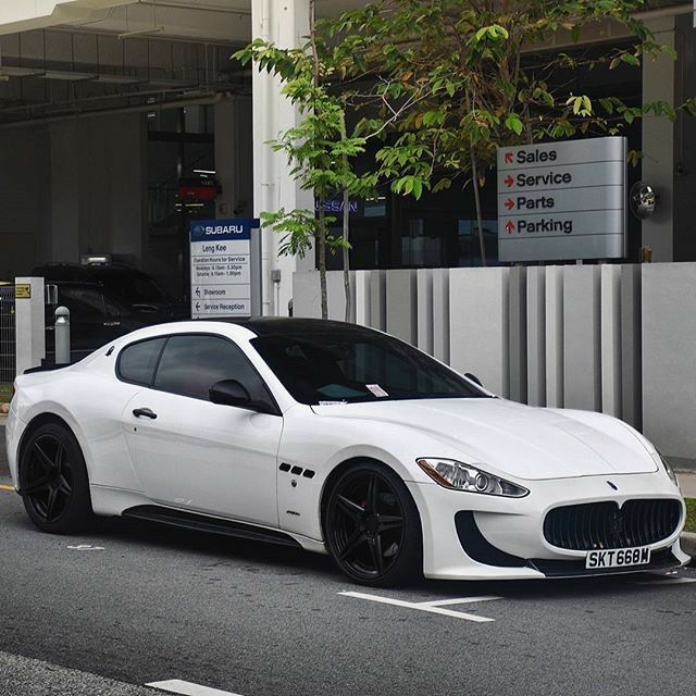 a white sports car parked in front of a building