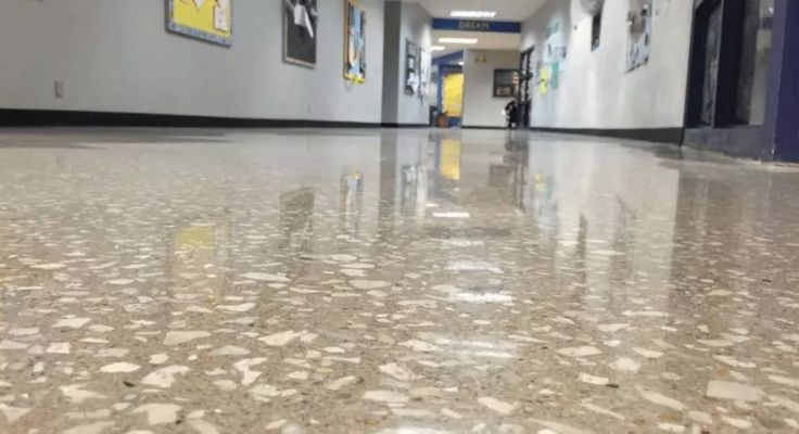 an empty hallway with pictures on the wall and floor in front of it, as well as a yellow fire hydrant