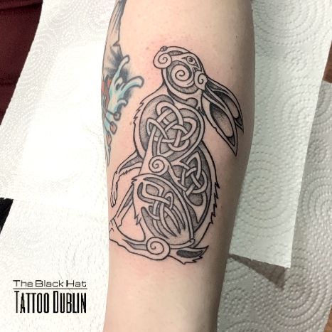 a tattoo design on the arm of a person with a bird and celtic knot work