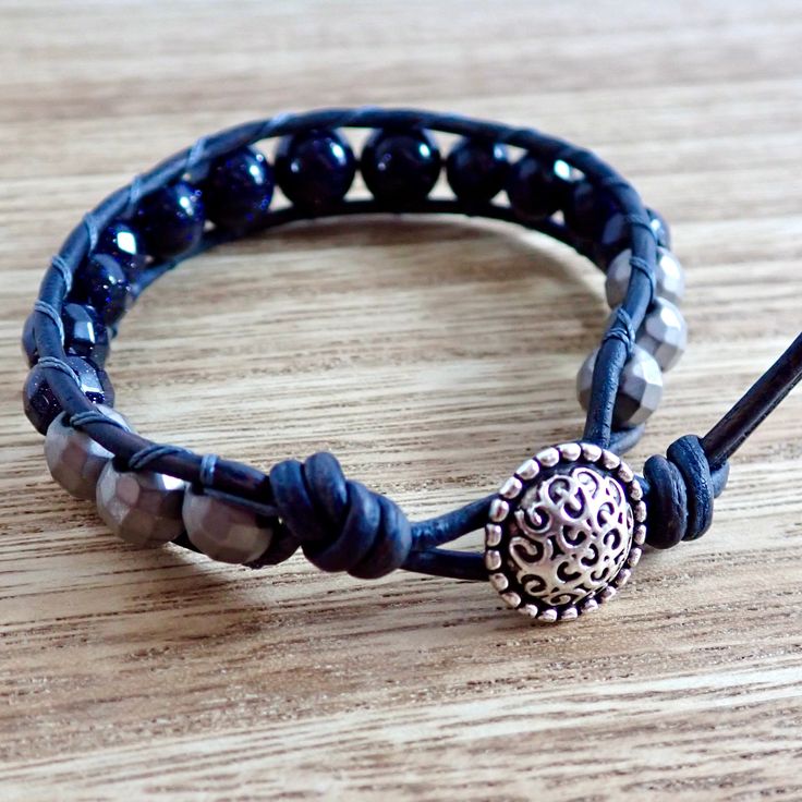 The glittering deep blue beads of this bracelet are stitched between two strands of soft navy blue leather. An antiqued silver button acts as the closure for this stackable wrap bracelet. Due to the fact that my jewelry is hand produced and uses natural gemstones and leather there may be some slight variations from piece to piece. The variations will be minor enough that you won't be surprised by any items you receive, they mark the pieces as truly one of a kind, handmade accessories! Materials Adjustable Hand Wrapped Leather Bracelet With Round Beads, Adjustable Hand-wrapped Beaded Leather Bracelet, Adjustable Beaded Leather Bracelet - Spiritual Style, Adjustable Beaded Leather Bracelet Spiritual Style, Adjustable Spiritual Wrap Bracelet With Faceted Beads, Spiritual Adjustable Beaded Leather Bracelet, Adjustable Leather Beaded Bracelets With Round Beads, Adjustable Hand-strung Leather Bracelet With Round Beads, Adjustable Wrap Bracelet With Black Round Beads