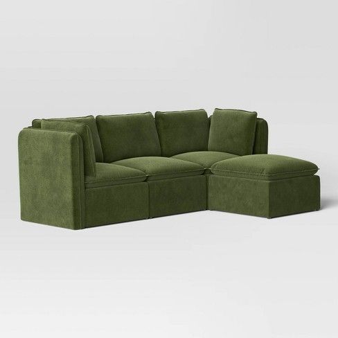 a green sectional couch sitting on top of a white floor