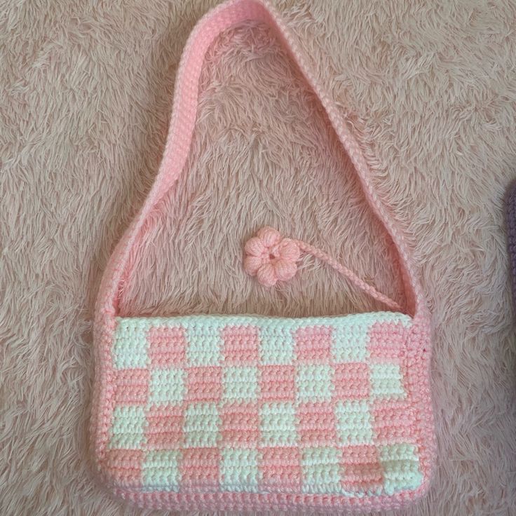 a pink and white purse sitting on top of a carpet