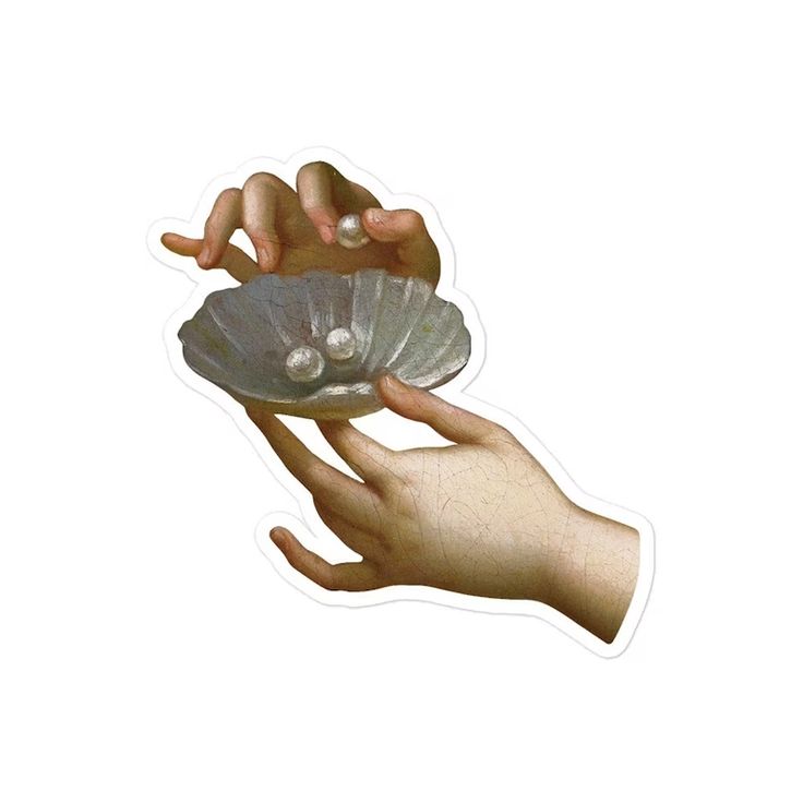 a hand holding a shell with two pearls on it's end and another hand reaching for the shell