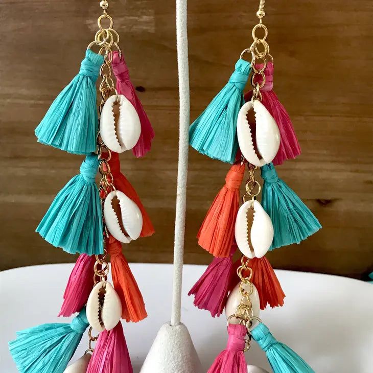 Make a big splash with our multi-color raffia tassel earrings! 🎉 Featuring effortlessly elegant, sleek cowrie shells and vibrant boho-chic tassels, these statement makers are the ultimate beach vibe upgrade. Rock the beachy vibes and turn heads with our multi-color version! 🌈 Let these fabulously chic beachy statement makers tassels sway down to on your shoulders! They're extra-long, pure luxe, lightweight and comfortable.🌴 Features Material: Cowrie Shell and Raffia Drop length: 6.5 inches; w Summer Festival Trendy Tassel Earrings, Trendy Summer Festival Tassel Earrings, Vibrant Beach Earrings, Chic Dangle Jewelry For Beach, Chic Dangle Jewelry For The Beach, Chic Summer Dangle Tassel Earrings, Chic Summer Jewelry With Tassels, Chic Tassel Earrings For Summer, Multicolor Fringe Tassel Earrings For The Beach