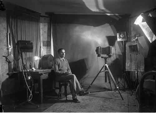 black and white photograph of a man sitting in front of a camera