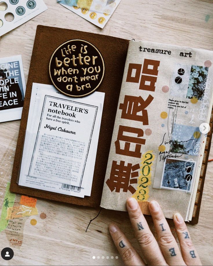 an open book sitting on top of a wooden table next to other books and magnets