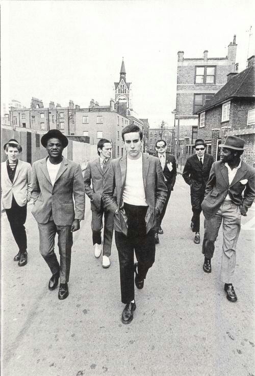 a group of men walking down a street next to each other in suits and ties