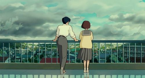 two people are standing on a balcony looking at the sky and clouds in the distance