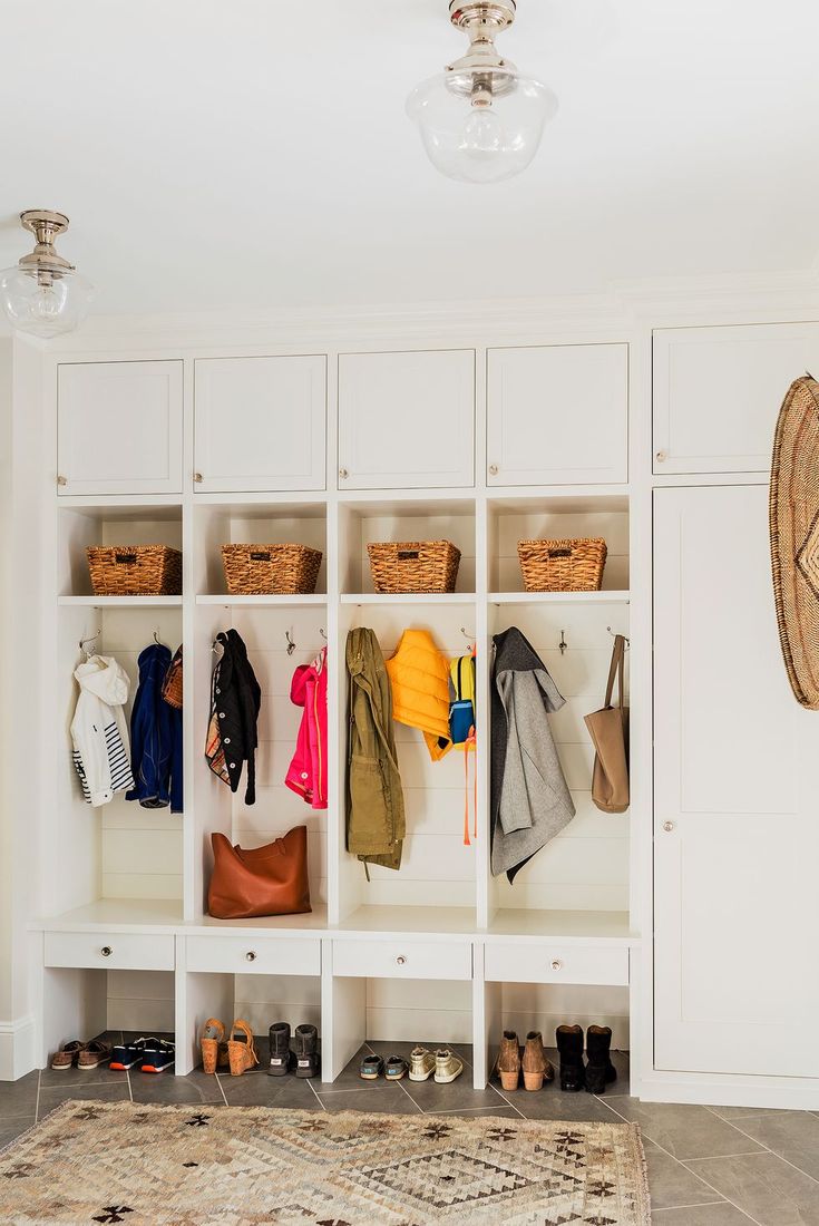 a white closet filled with lots of coats and shoes