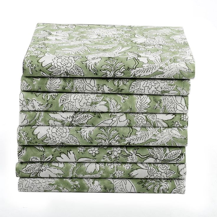 four green and white floral sheets stacked on top of each other