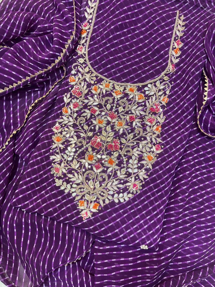 an embroidered purple blouse with floral embroidery on the chest and shoulder, along with matching pants