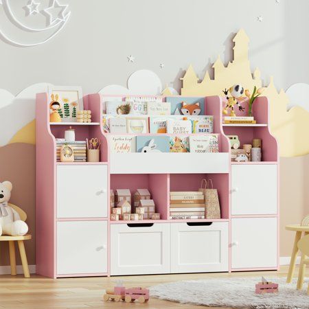 a child's room with pink and white furniture, toys and bookshelves