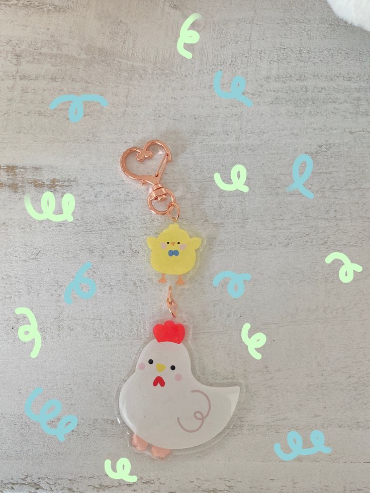 a keychain with a chicken and chick on it