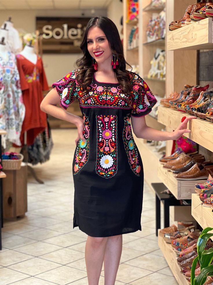 This Beautiful Dress boasts a Traditional Mexican floral design combined with a modern style dress. The colorful flowers combined with the split sleeve design make it fun and flirty. It's made out of fine Mexican cotton, is completely embroidered by hand with cotton string and some knit details. This dress is handmade and hand embroidered by Mexican Artisans in Puebla, Mexico. Purchase the earrings modeled here: https://www.etsy.com/es/listing/1095308086/arete-artesanal-mexicano-aretes?ref=listi Multicolor Embroidered Dress For Spring Fiesta, Multicolor Midi Dress With Floral Embroidery, Black Short Sleeve Dress For Fiesta, Black Dresses For Spring Fiesta, Multicolor Short Sleeve Dress For Fiesta, Embroidered Multicolor Summer Midi Dress, Multicolor Floral Print Dress For Fiesta, Black Embroidered Dress For Spring Fiesta, Black Embroidered Dress For Fiesta In Spring