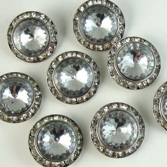 six silver colored glass buttons with clear crystal stones on the center and sides, all surrounded by smaller round ones