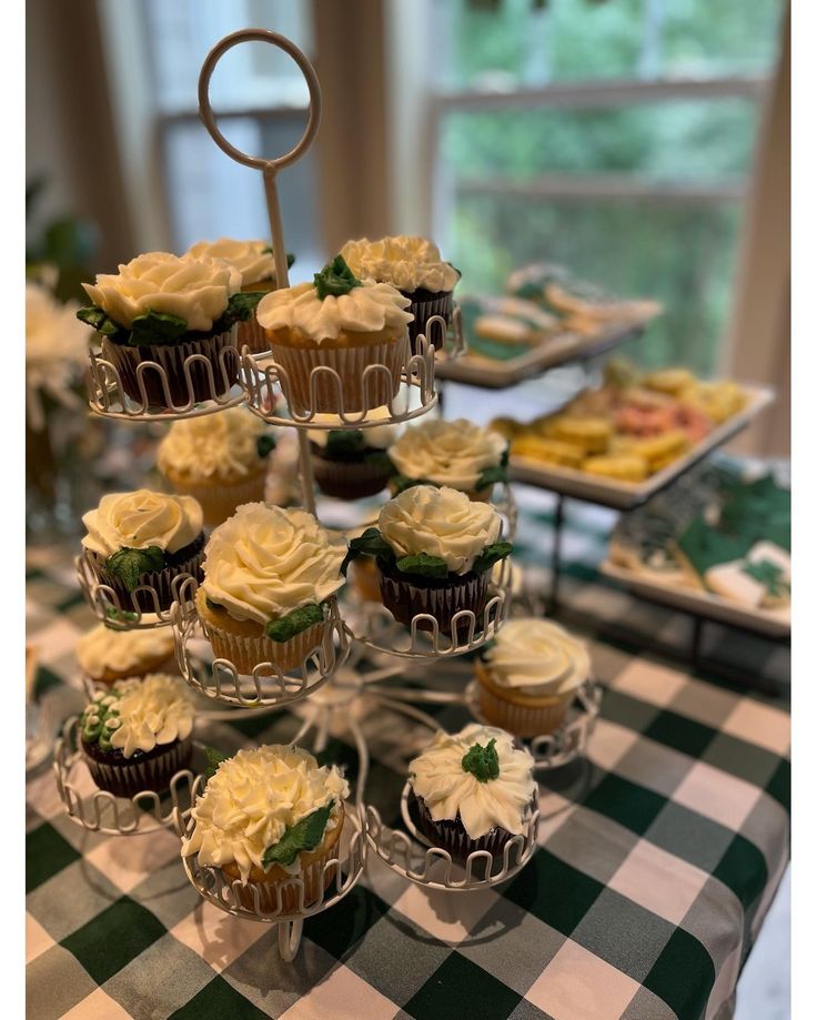 several cupcakes are arranged on a table with green and white checkered cloth