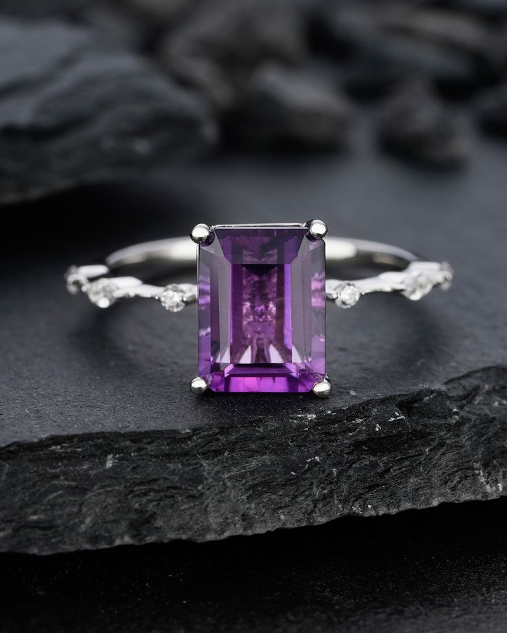 Amethyst- 3.0 Carat Fantastic Gemstone. ★Description *Center stone: 7x9mm Emerald Cut Classical Purple Amethyst. *Accent stone: 0.1Ct Princess Cut Moissanite(14K gold only) or CZ * Material: Sterling Silver with White/Yellow/Rose Gold Plated or Solid 14k Gold( White/Rose/Yellow gold) *Band Width(Bottom): 1.6-1.7mm Gemstone can be replaced with other birthstone, if you would prefer a custom ring, please contact us. ★Procedure information Please select the material and ring size from the drop-down Luxury Amethyst Ring With Cushion Cut Center Stone, Luxury Amethyst Rectangular Stone Ring For Gift, Fine Jewelry Purple Amethyst Ring With Prong Setting, Purple Emerald-cut Birthstone Ring For Anniversary, Emerald Cut Amethyst Ring In Fine Jewelry Style, Emerald Cut Amethyst Ring, Fine Jewelry Style, Purple Amethyst Ring With Emerald Cut And Gemstone Accents, Emerald Cut Amethyst Ring Fine Jewelry, Purple Emerald Cut Amethyst Ring With Gemstone Accents