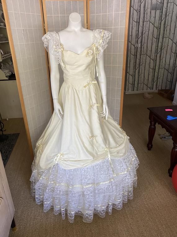 Amazing! 1980’s light yellow and white lace and floral full hoop skirt dress! Very light, cotton poly material, single layer. Has visible stains, but faint from a distance. Total beauty and the beast look!Bust: 34”Waist: 26”Hips freeWaist to hem: 45” Vintage Cream Ball Gown Dresses, Fitted Cream Victorian Ball Gown, Cream Lace Ball Gown, Vintage White Corset Dress For Costume Party, Vintage Victorian Ball Gown For Fancy Dress, Snow White Fitted Wedding Dress, White Victorian Marie Antoinette Dress For Costume Party, White Marie Antoinette Victorian Dress For Costume Party, Cream Ball Gown For Debutante Ball