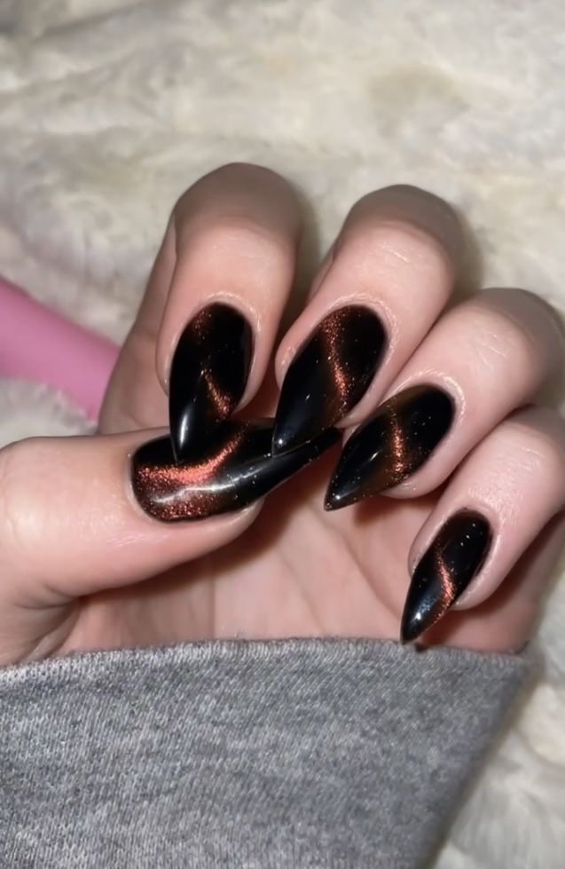 Black And Orange Cat Eye Nails, Stiletto Cat Eye Nails, Black Cat Eye Nail Ideas, Black Cats Eye Nails, Almond Shape Halloween Nails, Fall Nails Stilleto Shape, Orange Cat Eye Nails, Cat Eye Nails Black, Black Cat Eye Nails Design