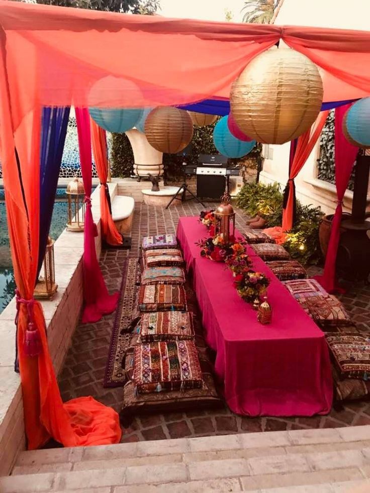 an outdoor seating area is decorated with lanterns and paper lanterns for the canopy over it