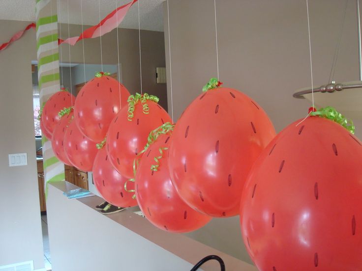 balloons are hanging from the ceiling in front of a mirror