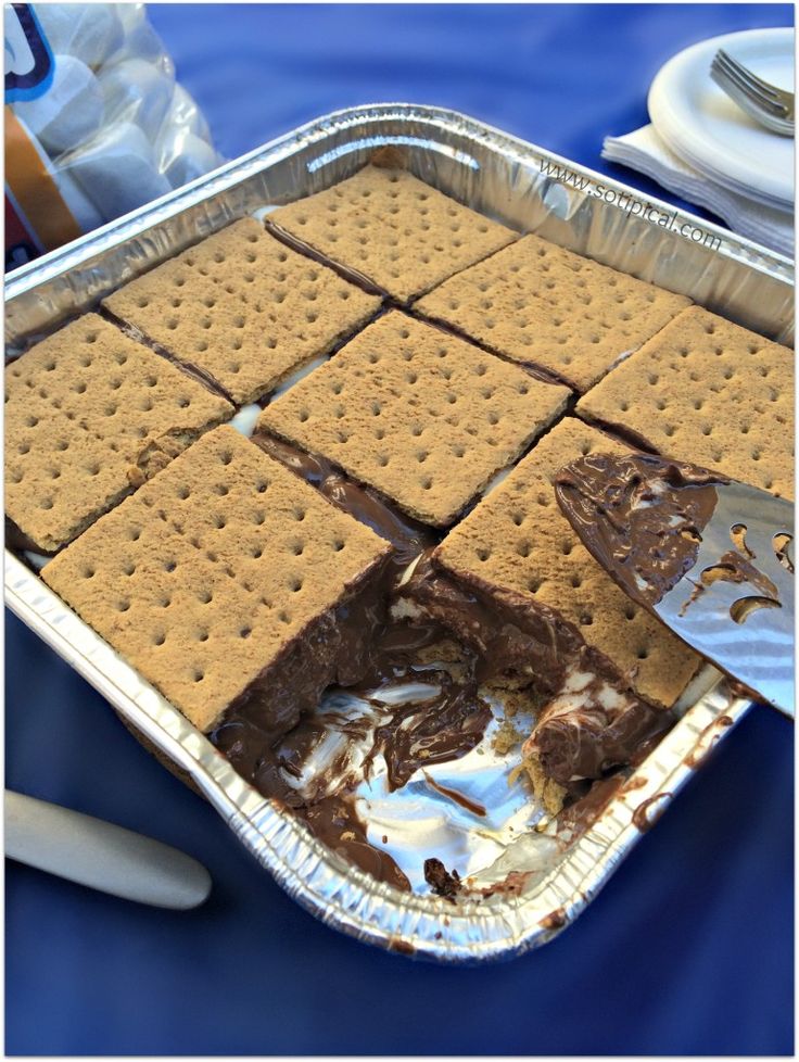 a pan filled with crackers and ice cream on top of a blue table cloth