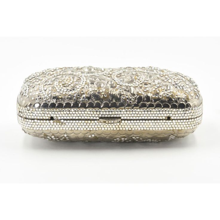 Elegant Judith Leiber silver metal and crystal oblong evening bag clutch featuring a scrolling foliage flower design on a silver - toned metal bag.  The hardware is silver.  It has a silver leather interior with a silver shoulder strap that can be folded inside when you want to wear it as a clutch.  There is a circle that folds out to hold a tassel, but it is no longer there.  Labeled ‘Judith Leiber/New York’ in the interior. 5.5” W x 3” H x 1.5” D  A similar one sold at Chrisities from Joan Riv Designer Silver Clutch For Formal Events, Designer Silver Clutch For Formal Occasions, Silver Evening Bag With Rectangular Case Shape, Silver Evening Bag Rectangular Case, Luxury Silver Clutch, Designer Silver Rectangular Clutch, Elegant Engraved Gold Bags, Luxury Evening Clutch With Silver-tone Hardware, Luxury Formal Clutch With Silver-tone Hardware