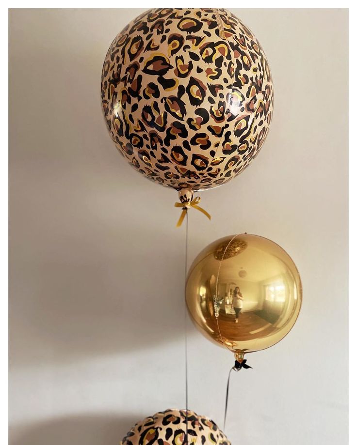 two balloons with leopard print on them hanging from the ceiling