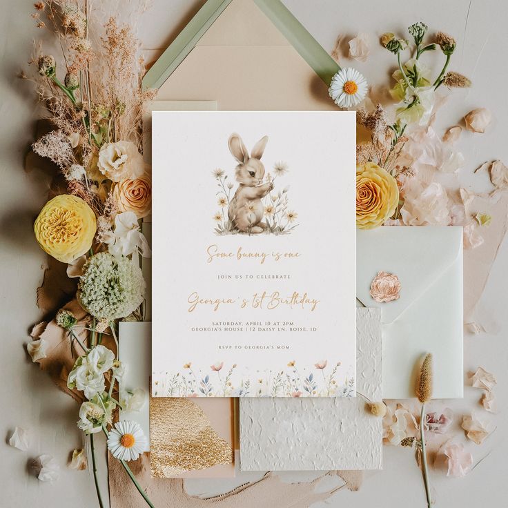 the wedding stationery is surrounded by flowers