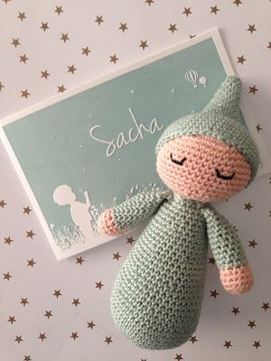 a crocheted stuffed animal sitting next to a card