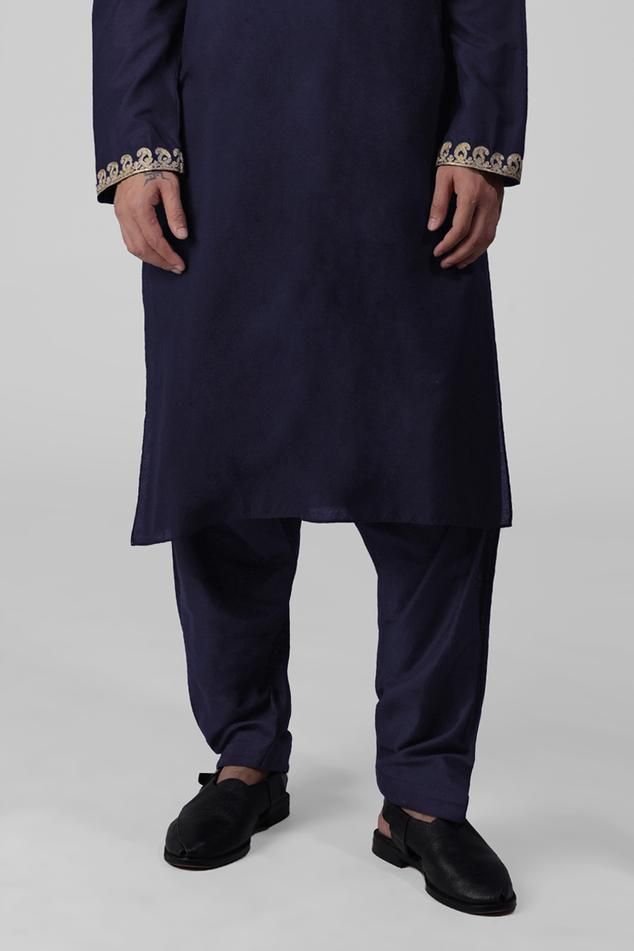 Navy blue kurta featuring intricate tilla embroidery and delicate gold silk thread work on the front placket, sleeves, and neckline. Paired with a pathani salwar.
Components: 2
Pattern: Embroidered
Type Of Work: Tilla
Neckline: Band collar
Sleeve Type: Long
Fabric: Silk
Color: Blue
Other Details: 
Attached lining
Length:
Kurta: 47 inches
Sleeve: 27 inches
Placket: 15.5 inches
Salwar: 42 inches
Occasion: Mehendi and Puja - Aza Fashions Embroidered Slub Silk Sherwani For Eid, Eid Embroidered Slub Silk Sherwani, Embroidered Slub Silk Sherwani With Traditional Drape, Traditional Embroidered Slub Silk Sherwani, Traditional Slub Silk Sherwani For Transitional Season, Designer Embroidered Indigo Kurta, Blue Cotton Silk Salwar Kameez With Embroidered Border, Embroidered Straight Kurta In Indigo, Indigo Embroidered Straight Kurta