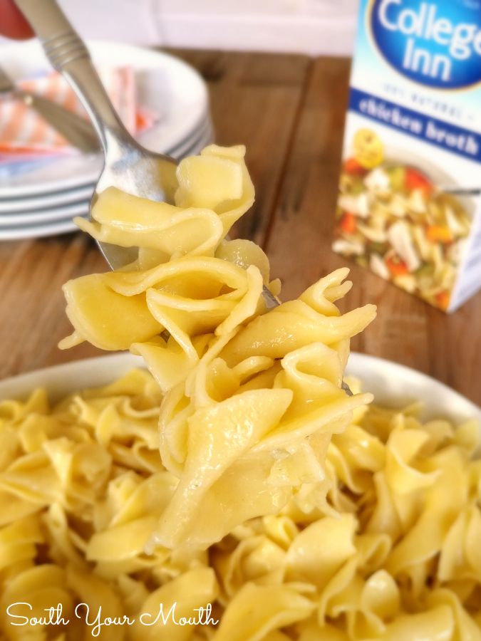 a spoon full of noodles with a carton of milk in the background