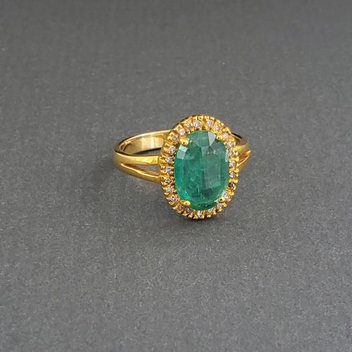 This big beautiful Columbian emerald is surrounded by diamonds set into 14k gold. This piece would make a gorgeous alternative engagement ring! Luxury Modern Yellow Gold Emerald Ring, Luxury Yellow Gold Oval Emerald Ring, Gold Baguette Cut Ring With Halo Setting, Gold Rings With Halo Setting In Baguette Cut, Yellow Gold Ring With Baguette Cut Halo Setting, Gold Diamond Ring With Baguette Cut And Halo Setting, Exquisite 14k Gold Rings For Formal Occasions, Dazzling Yellow Gold Sapphire Ring With Brilliant Cut, 14k Gold Halo Ring With Prong Setting