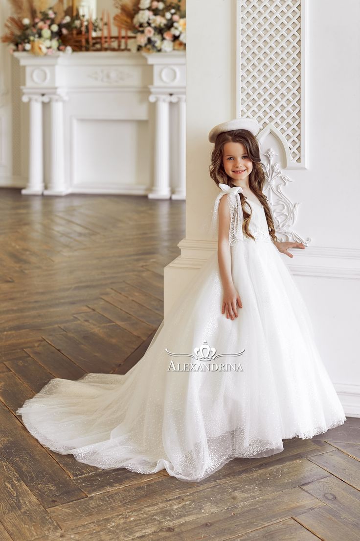 Wonderful snow-white dress in shimmering fabric with lace decorA charming white princess outfit. The dress is made of translucent fabric with a beautiful wavy ornament and shimmering sequins. Floral lace trims the V-neck bodice. Addition - fluffy sleeves and bows on the shoulders. The A-line skirt is completed with a long train. #flowergirldress #princessdress #communiondress Fluffy Sleeves, Translucent Fabric, Birthday Party Dresses, Dresses Birthday, Flower Girl Gown, Princess Outfit, Snow White Dresses, Girls Special Occasion Dresses, First Communion Dresses