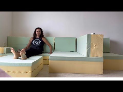 a woman sitting on a couch made out of mattresses