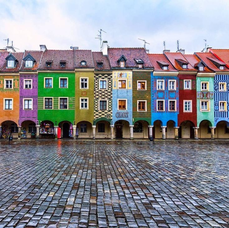 the colorful buildings are all lined up on the cobblestone street in front of each other