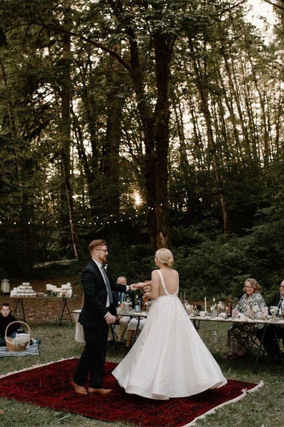 a bride and groom standing in front of an outdoor table