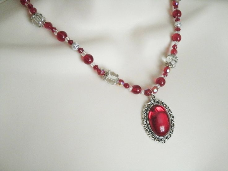 "Red Necklace This beautiful necklace has red glass beads, clear glass beads, seed beads, sterling silver plated filigree beads, sterling silver plated bead caps and a pewter silver pendant with red glass setting. 18\" long. Sterling silver plated toggle clasp." Red Gothic Necklace For Formal Occasions, Gothic Beaded Wedding Jewelry, Red Ruby Victorian Necklace, Elegant Crystal Necklaces For Valentine's Day Jewelry Making, Handmade Victorian Jewelry For Valentine's Day, Elegant Beaded Necklaces For Valentine's Day, Elegant Handmade Beaded Necklaces For Valentine's Day, Elegant Handmade Beaded Necklace For Valentine's Day, Valentine's Day Elegant Beaded Necklaces