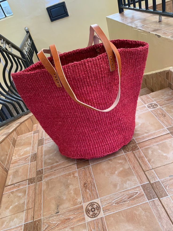 Kiondo overview A beautiful hand made kiondo bag in Cherry red color. A wonderful art piece for your everyday activities and a great gift for a loved one. The bag is made of sisal fiber that is hand picked hand prepared into yearn then twisted and weaved. It is finished with natural leather mainly from cow hide. Uses Day out: Its a great bag for use in carrying personal effects such as outdoor mats,sandals and other picnic items Shopping: The bag has large space that can adequately accommodate y Red Large Capacity Rectangular Bucket Bag, Red Rectangular Large Capacity Bucket Bag, Red Rectangular Bucket Bag With Large Capacity, Handmade Red Bucket Bag For Everyday Use, Red Rectangular Bucket Bag For Travel, Eco-friendly Red Shoulder Bag For Shopping, Red Bucket Bag With Large Capacity And Top Handle, Eco-friendly Bucket Shape Shoulder Bag For Shopping, Large Capacity Red Beach Bag For Travel