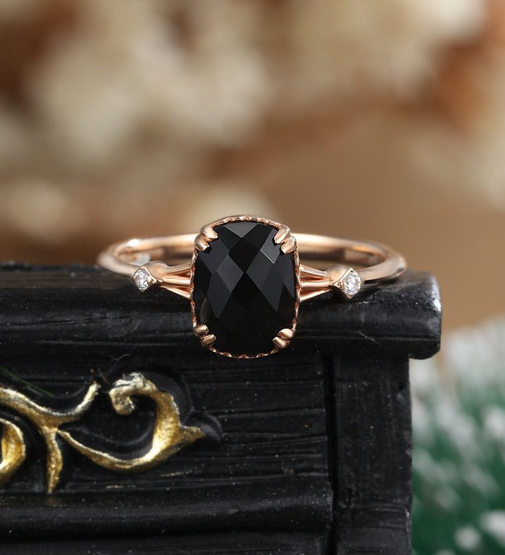 a black diamond ring sitting on top of a wooden table