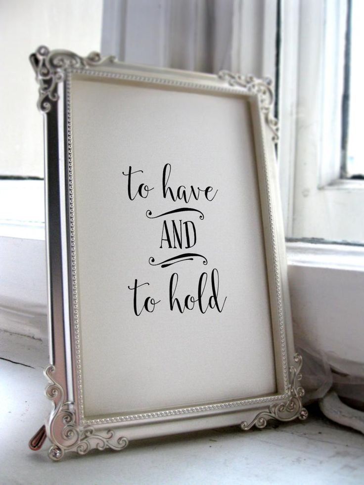 a white frame with the words to have and to hold on it next to a window