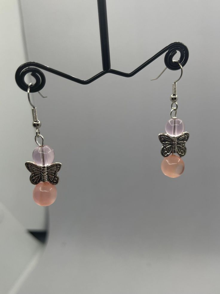 Pretty and cute these fairycore beaded butterfly earrings are the perfect gift and or accessory for anyone who likes dainty earrings. Made with: mixed round crystal beads and silver butterfly beads. Length: 1.1 inches and your choice of sterling sterling silver hook earrings. Handmade Pink Fairy Jewelry, Pink Butterfly Charm Earrings, Pink Butterfly Charm Drop Earrings, Pink Drop Earrings With Butterfly Charm, Pink Butterfly Charm Dangle Jewelry, Pink Dangle Jewelry With Butterfly Charm, Pink Sterling Silver Beaded Earrings Gift, Whimsical Pink Butterfly Jewelry, Pink Fairycore Earrings As Gift