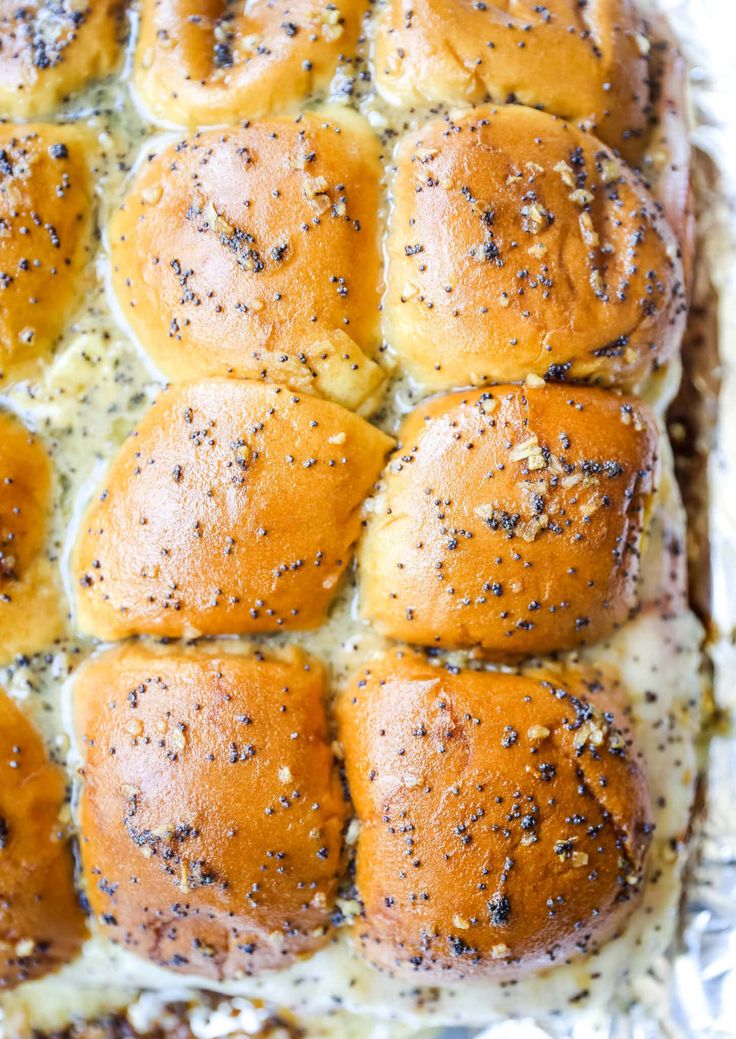 hot cross buns with cheese and seasoning sprinkled on top in a baking pan