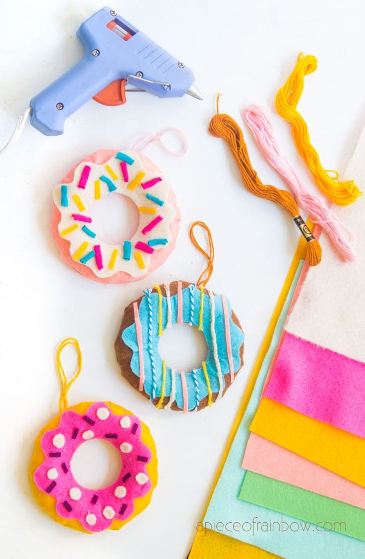 craft supplies including doughnuts, yarn and scissors on a white surface with rainbow colors