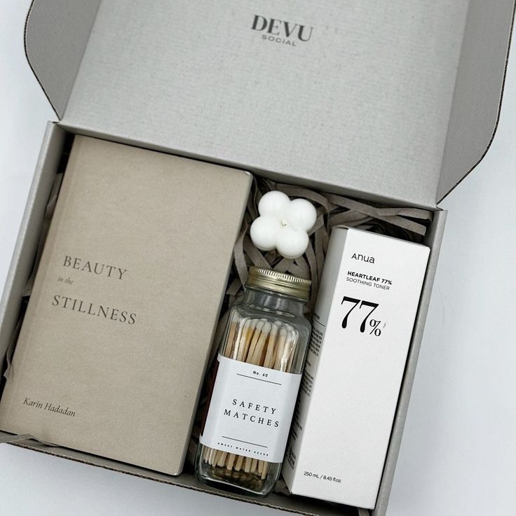 an open box containing matches, candles and a bottle of wine with the word beauty on it