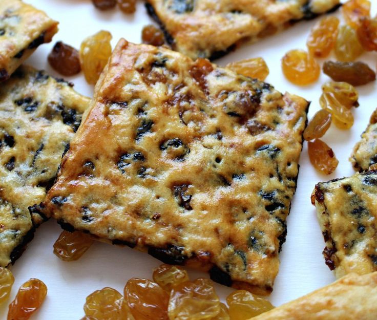 some crackers and raisins are on a white surface