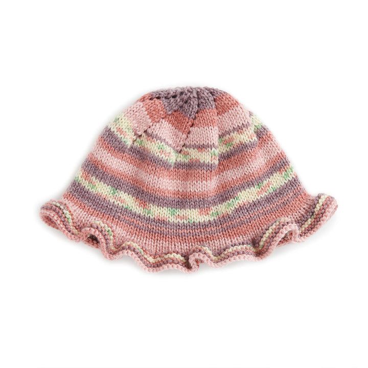 a knitted hat with ruffles on the front and bottom, sitting against a white background