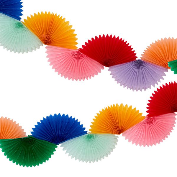 multicolored paper fans hanging from string on white background