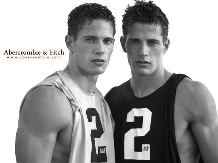 two young men standing next to each other in front of a blue and white background